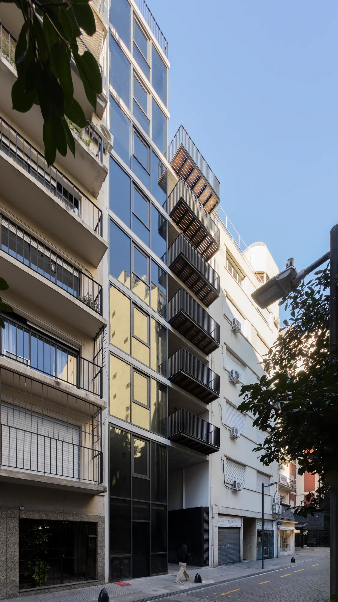 Fachada de Domos Plaza desde la calle, con balcones y paños vidriados